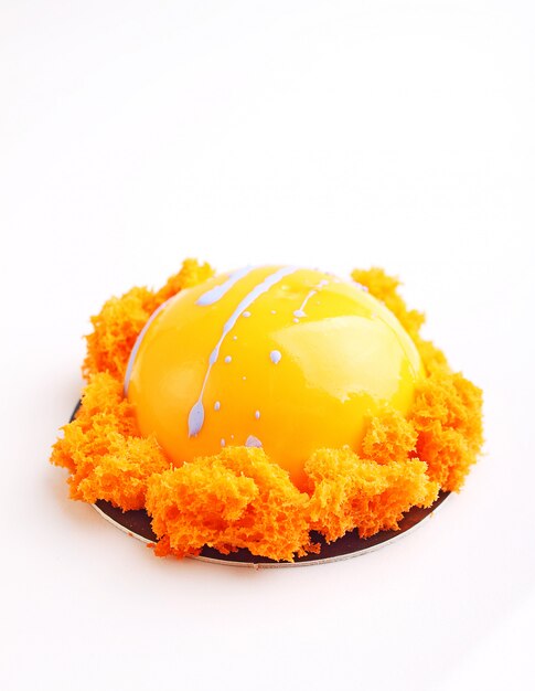Orangenkuchen in der Spiegelglasur ist mit molekularem Keks dekoriert. weißer Hintergrund