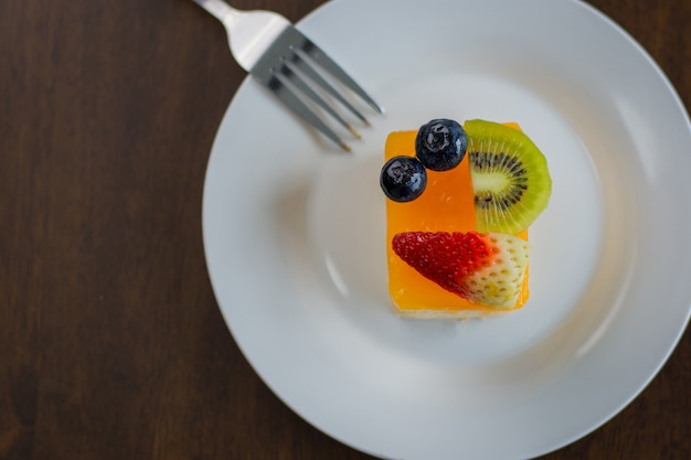 Orangenkuchen wird in einen herrlichen weißen Teller gelegt