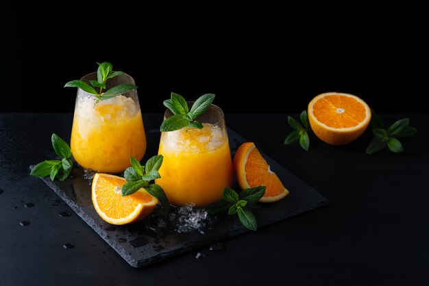 Orangenlimonade des kalten Sommers mit Minze und Eis in einem Glas Kopieren Sie Platz für Text