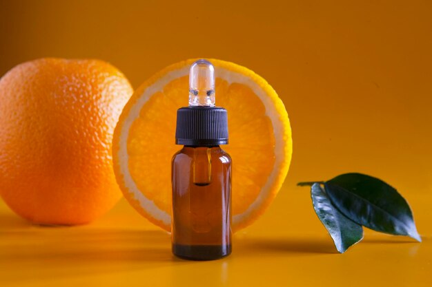 Foto orangenorganisches aromatisches öl in einer glasflasche mit einer pipette neben einer frischen orange