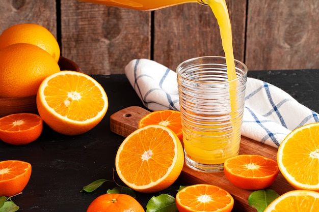 Orangensaft fließt aus der Flasche ins Glas