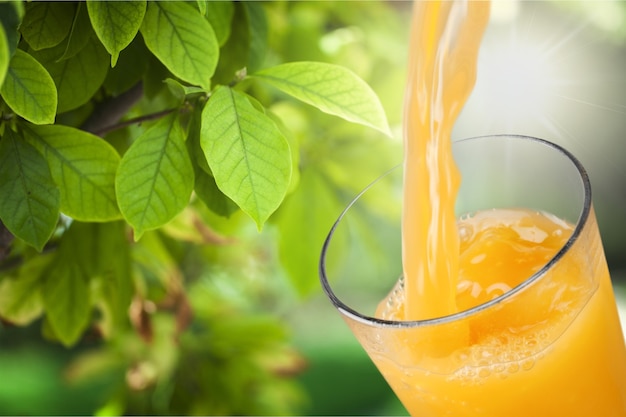 Orangensaft gießt in Glas auf Hintergrund