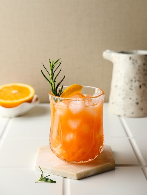 Orangensaft im Glas mit frischen Früchten der Minze auf Holzbrett Selektiver Fokus unscharfer Hintergrund