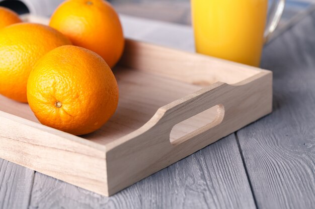 Orangensaft in Glas und frischem Obst auf einem Holz