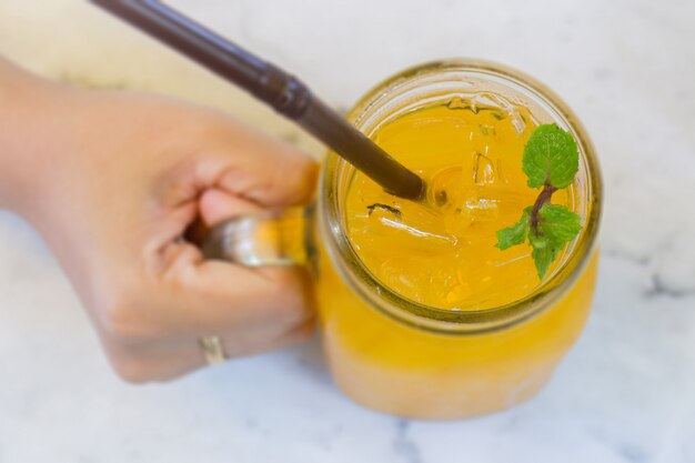 Orangensaft mit Eiswürfel auf Marmortabelle