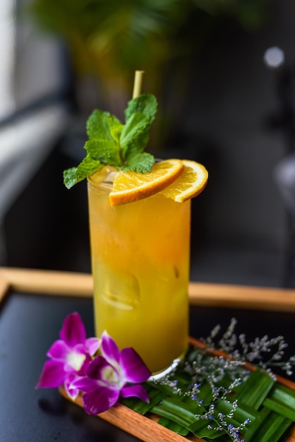 Orangensaft mit Orangenscheibe mit Blumen