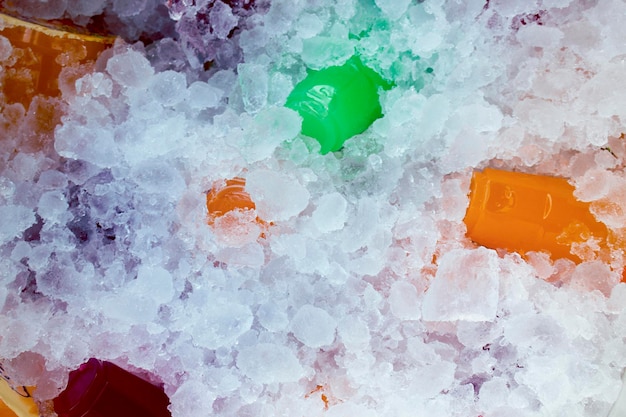 Orangensaft und buntes Süßwasser auf Eiskristallen