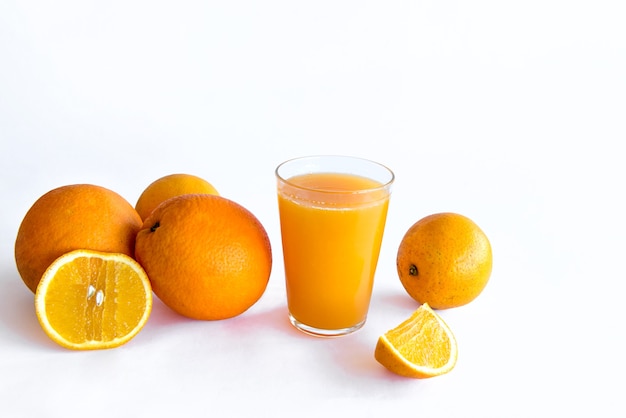 Orangensaft und Orangen auf weißem Hintergrund.