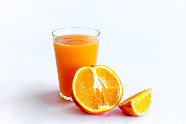 Orangensaft und Orangen auf weißem Hintergrund.