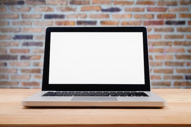 Foto ordenador con pantalla en blanco sobre la mesa con desenfoque de fondo.