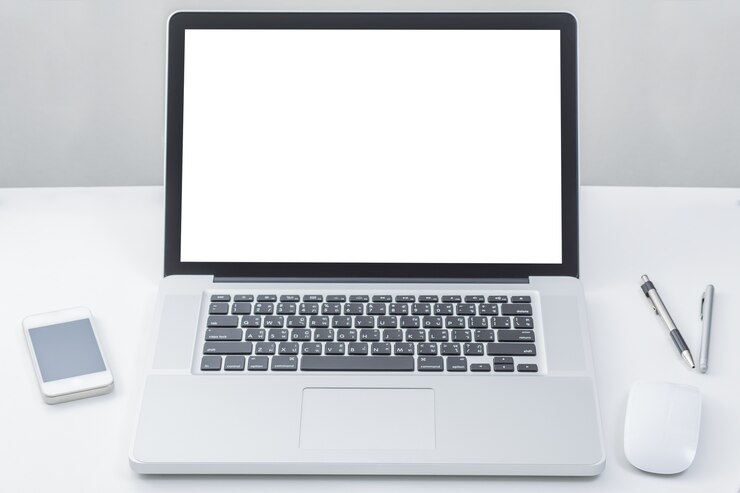 Foto ordenador portátil en la mesa con pantalla en blanco