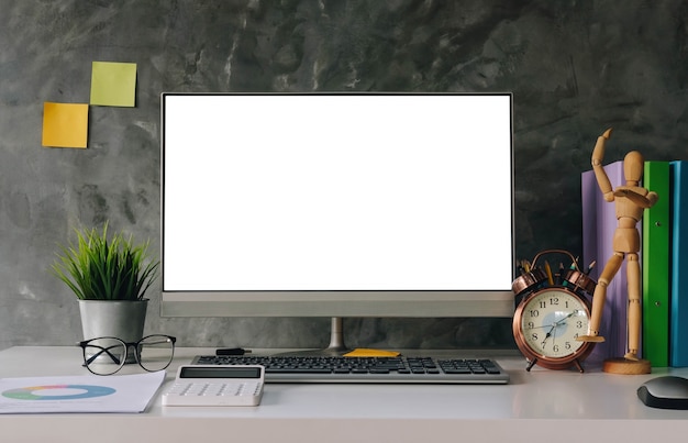Ordenador portátil de pantalla en blanco y fondo del espacio de trabajo del cartel en la oficina moderna