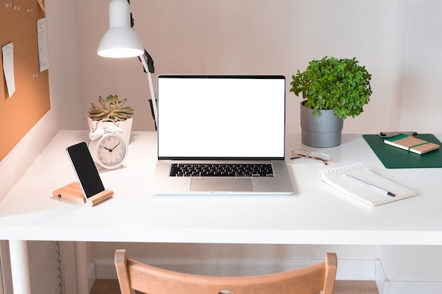 Ordenador portátil con pantalla en blanco en el interior del escritorio de oficina. Elegante vista de mesa de maqueta de lugar de trabajo de oro rosa.