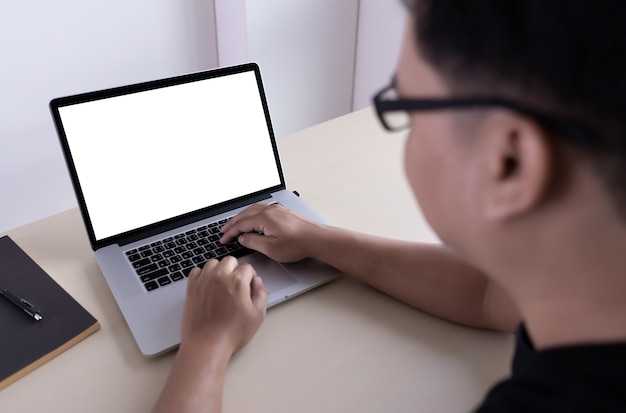 Ordenador portátil con pantalla en blanco en la mesa. Nuevo proyecto de fondo de área de trabajo en la computadora portátil con co en blanco