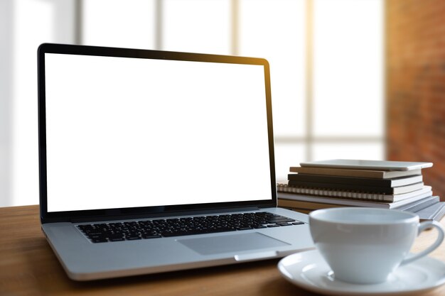 Ordenador portátil con pantalla en blanco en la mesa. Nuevo proyecto de fondo de área de trabajo en la computadora portátil con co en blanco