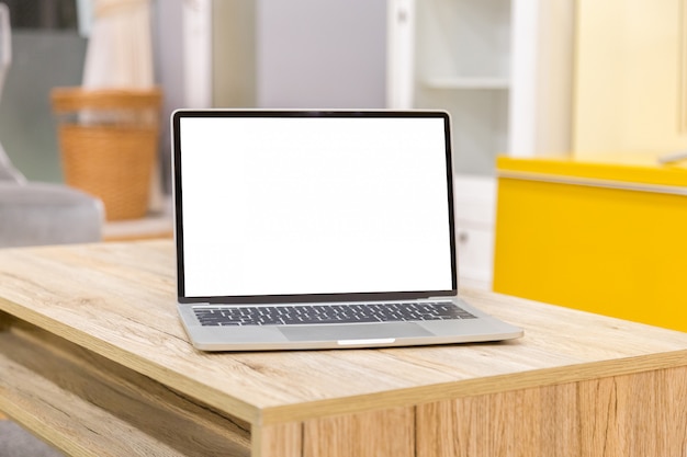 Ordenador portátil que muestra la pantalla en blanco en la vista frontal de la mesa de trabajo en casa