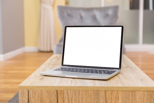 Ordenador portátil que muestra la pantalla en blanco en la vista frontal de la mesa de trabajo en casa