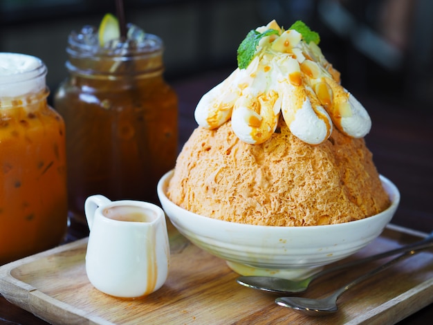 Ordeñe el té Bingsu (postre coreano) en la placa de madera.