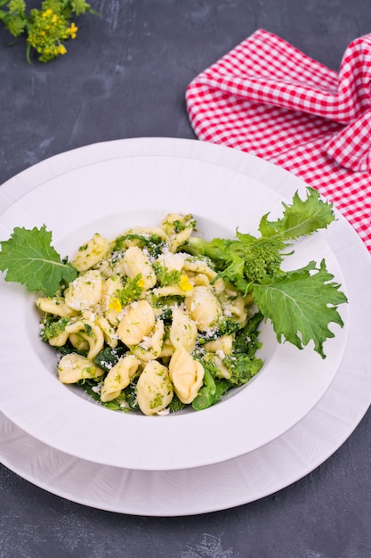 Orecchiette alla Pugliese, hausgemachte italienische Pasta. Orecchiette mit Rübenoberteilen. Traditionelles Essen aus Süditalien auf weißem Grund. Speicherplatz kopieren