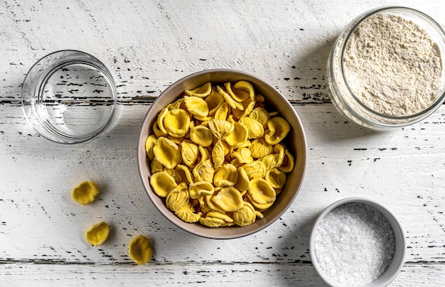 Orecchiette sind typisch italienische Nudeln aus Puglia Pasta in einer Schüssel mit Hauptzutaten beiseite Draufsicht