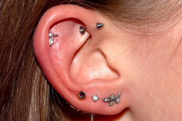 Foto la oreja de una mujer muchos piercings y aretes