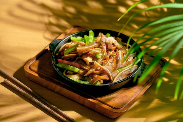 Orejas de cerdo en escabeche y fritas en una sartén. Cocina china.