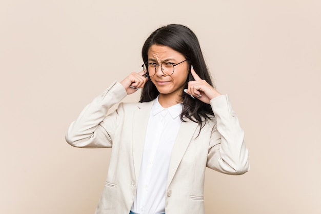 Orelhas da coberta da mulher chinesa nova do negócio com mãos.