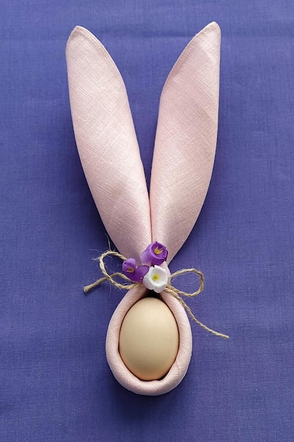 Orelhas de coelho decorativas com ovo na toalha de mesa de algodão roxo DIY flat lay