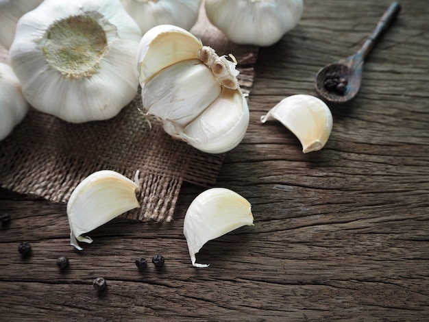 Foto orgánico, rebanadas de ajo sobre fondo de madera.