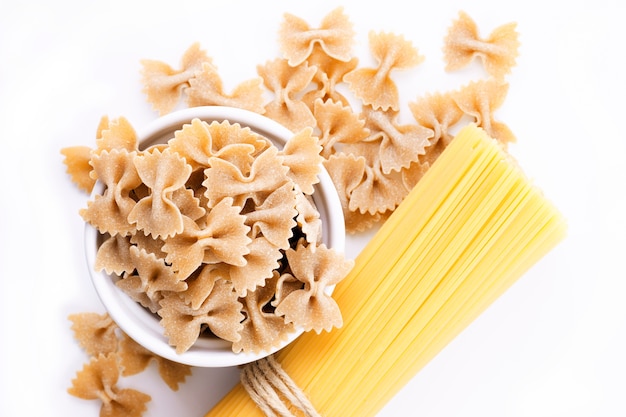 Foto organische farfalle teigwaren und spaghettis getrennt auf weiß