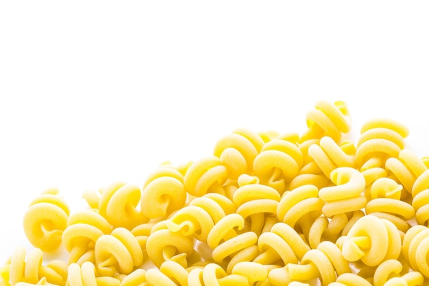 Organische gelbe italienische Trottole-Nudeln auf weißem Hintergrund.