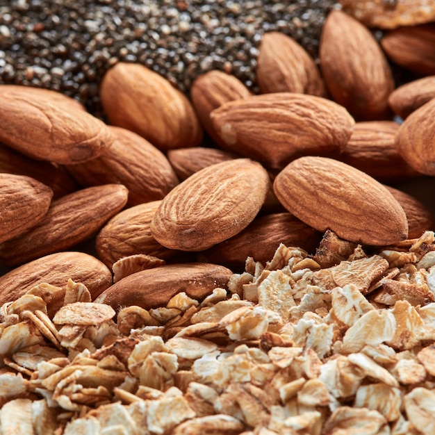 Organische Textur aus Mandeln und Hafergranola. Konzept der natürlichen vegetarischen Nahrung. Mandel- und Haferflockenmakrohintergrund mit weichem Fokus.