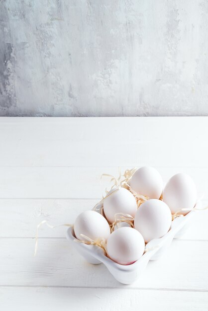 Organische weiße Hühnereien im dekorativen Kasten des Porzellans auf Weiß. Natürliche gesunde Nahrung und organisches Konzept.