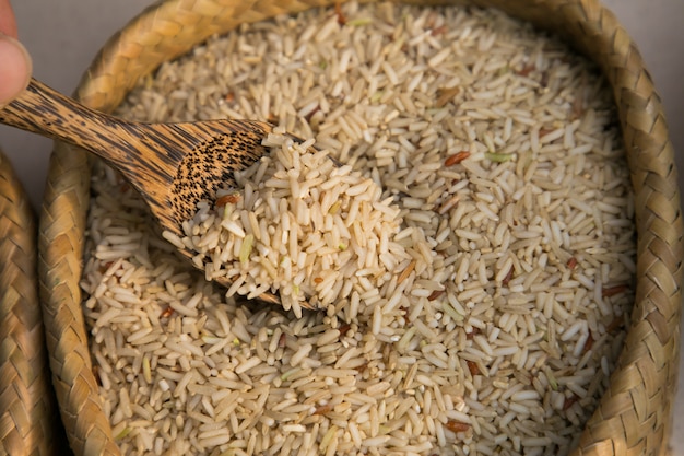 Organischer Brauenjasminreis und Holzlöffel im Webartvorrat. Essen Hintergrund