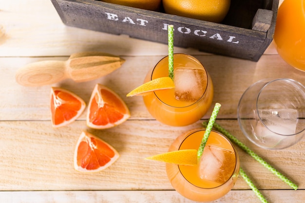 Organischer rubinroter Grapefruitsaft im kleinen Glas mit Eis.