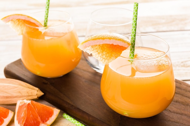 Organischer rubinroter Grapefruitsaft im kleinen Glas mit Eis.