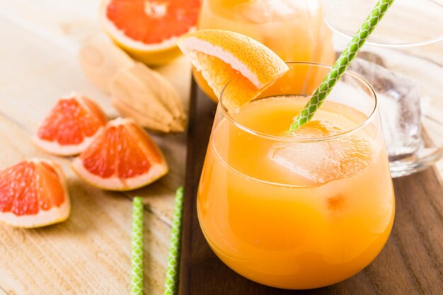 Organischer rubinroter Grapefruitsaft im kleinen Glas mit Eis.