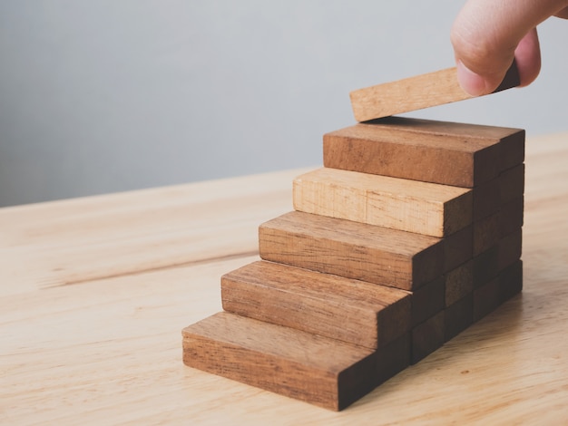 Organización manual de apilamiento de bloques de madera como escalón