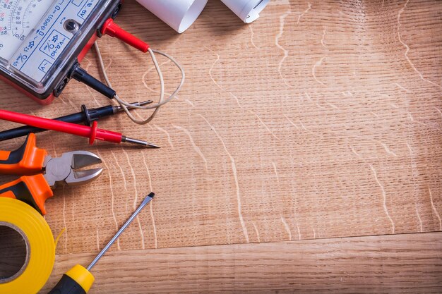 Organizado copyspace herramientas eléctricas probador multímetro tenazas destornillador rollo cinta aislante sobre placa de madera