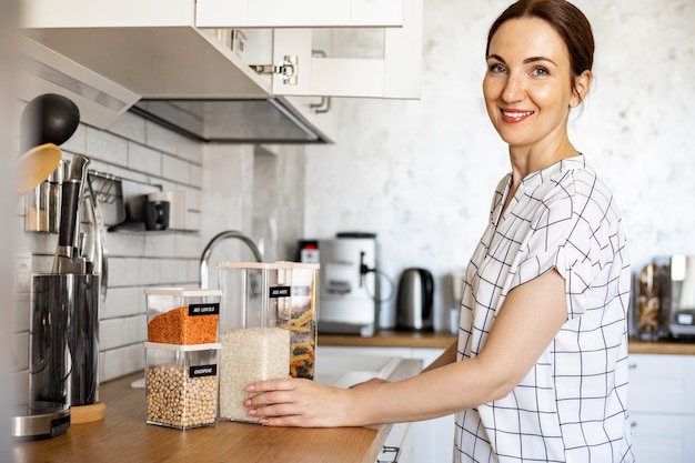 Organizador de espacio profesional de mujer sonriendo posando con estuches para un almacenamiento cómodo del producto