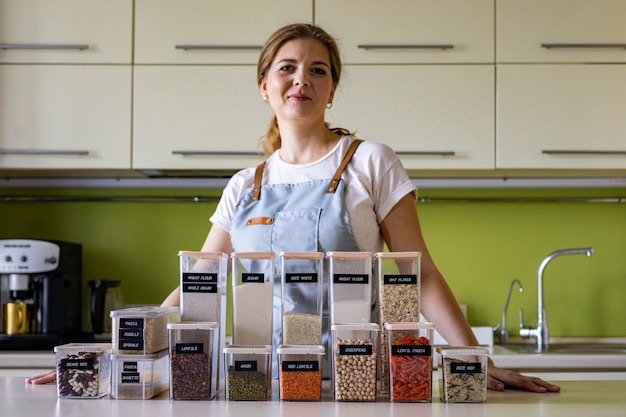 Organizador de espacio profesional de mujer sonriendo posando con estuches para un cómodo almacenamiento de productos