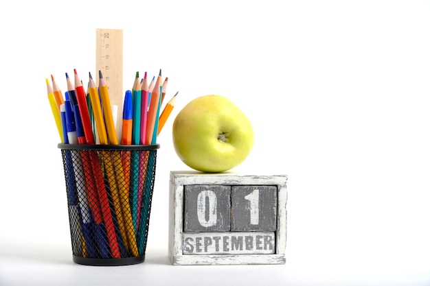 Organizador de manzana verde con lápices y soporte de papelería de regla y calendario con fecha 01 de septiembre Sobre fondo blanco