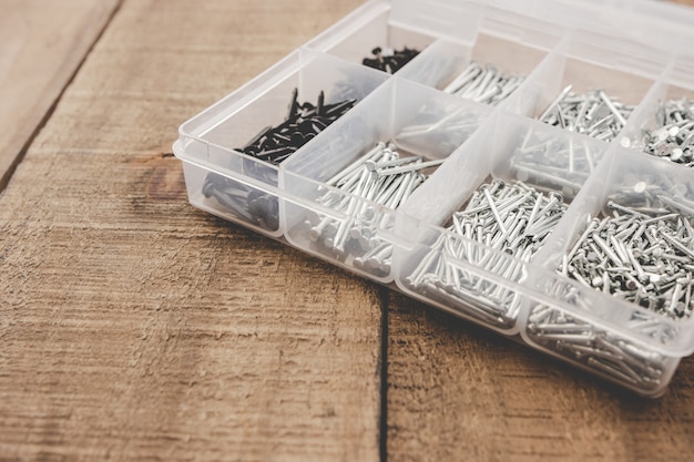 Organizador de uñas. Diferentes tamaños de uñas organizadas en una caja de plástico. Copia espacio