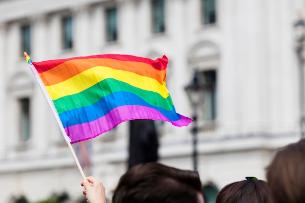 Orgulho gay, bandeiras do arco-íris LGBTQ sendo acenadas no ar em um evento de orgulho.