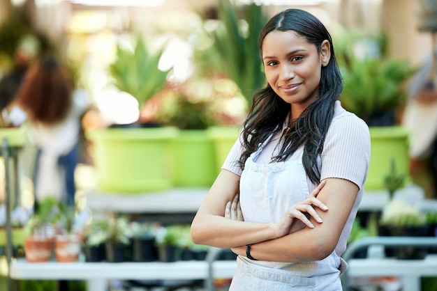 Orgullo feliz y retrato de una mujer en un jardín o vivero como propietaria de un negocio o empleada Experta en plantas sonrientes y trabajadora en una tienda de ecología en un parque con espacio de maquetas para venta minorista o servicio