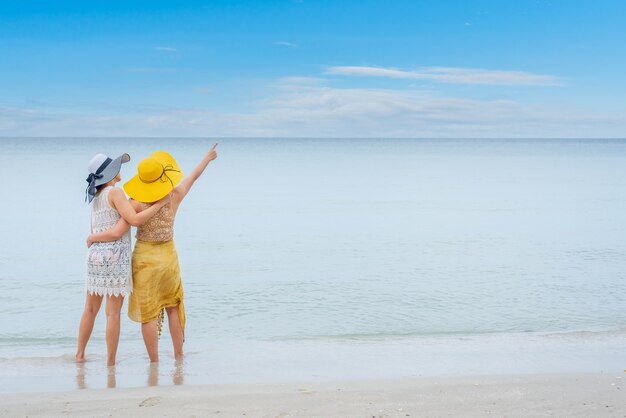 El orgullo y la pareja de amor LGBTQ en la playa de verano.