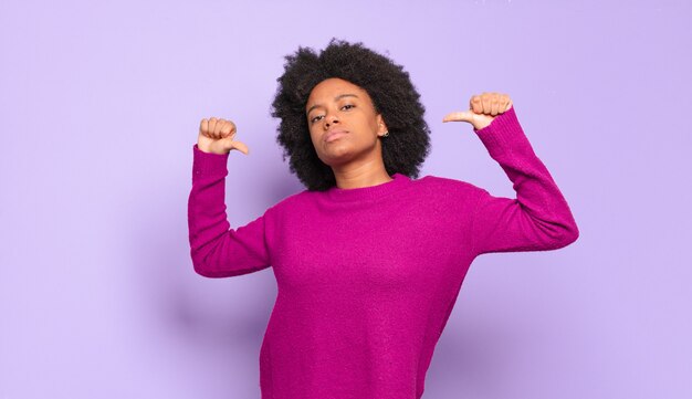 Orgullosa joven bastante negra apuntando a sí misma