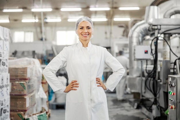 Foto un orgulloso inspector de una fábrica de alimentos sonríe a la cámara mientras está de pie en las instalaciones