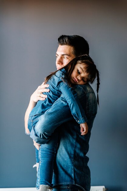 Orgulloso padre abraza a su hija en casa.