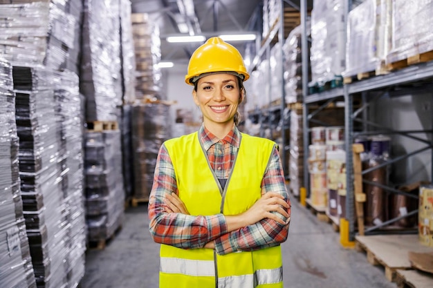 Foto el orgulloso trabajador del almacén sonríe a la cámara mientras está de pie en las instalaciones